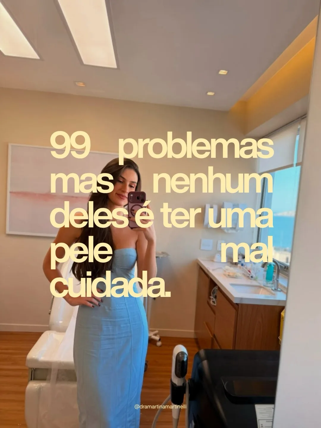 Selfie da Dra. Martina de vestido azul no espelho do consultório